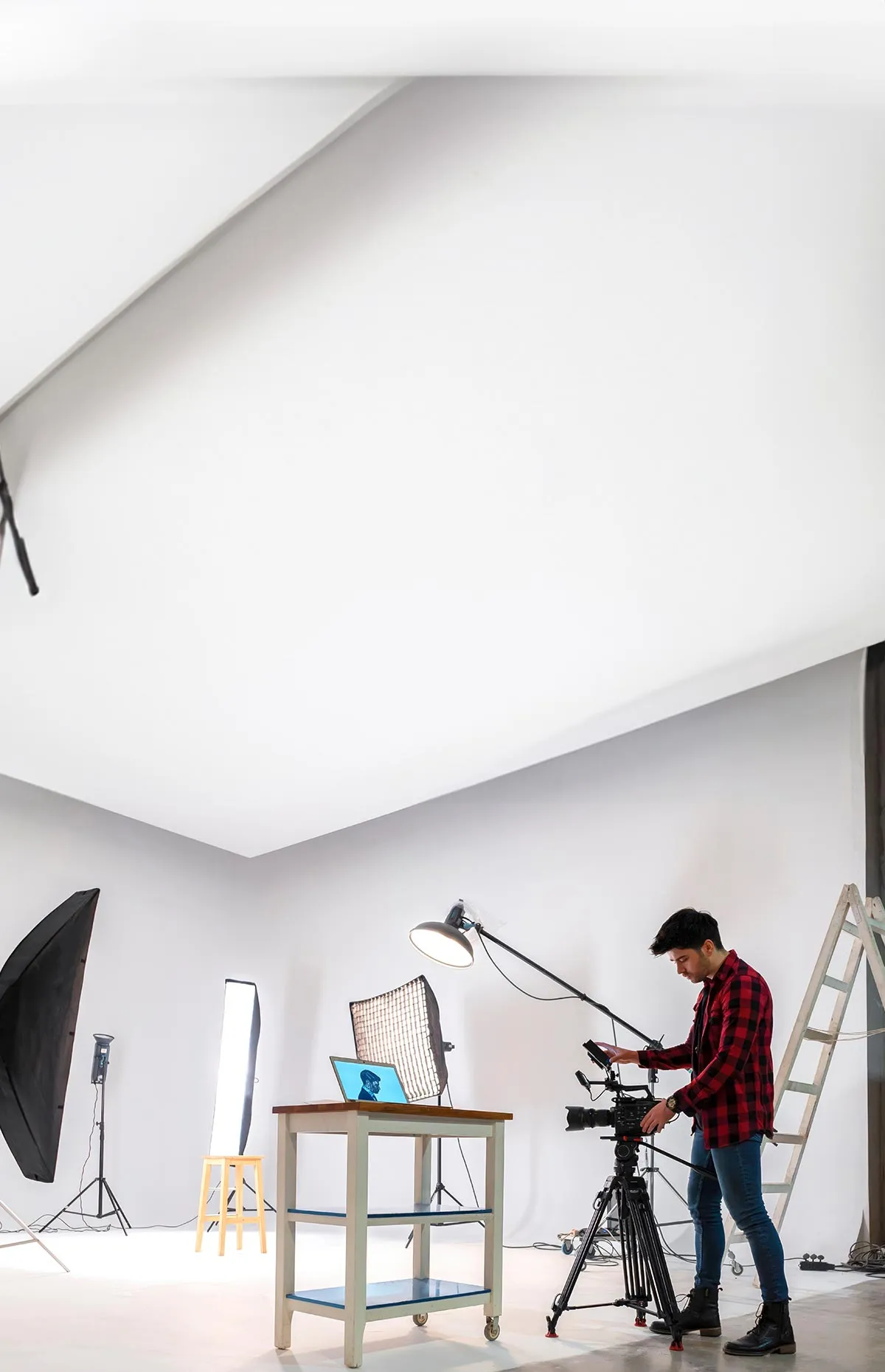 A content creator adjusts some camera equipment on a sound stage.